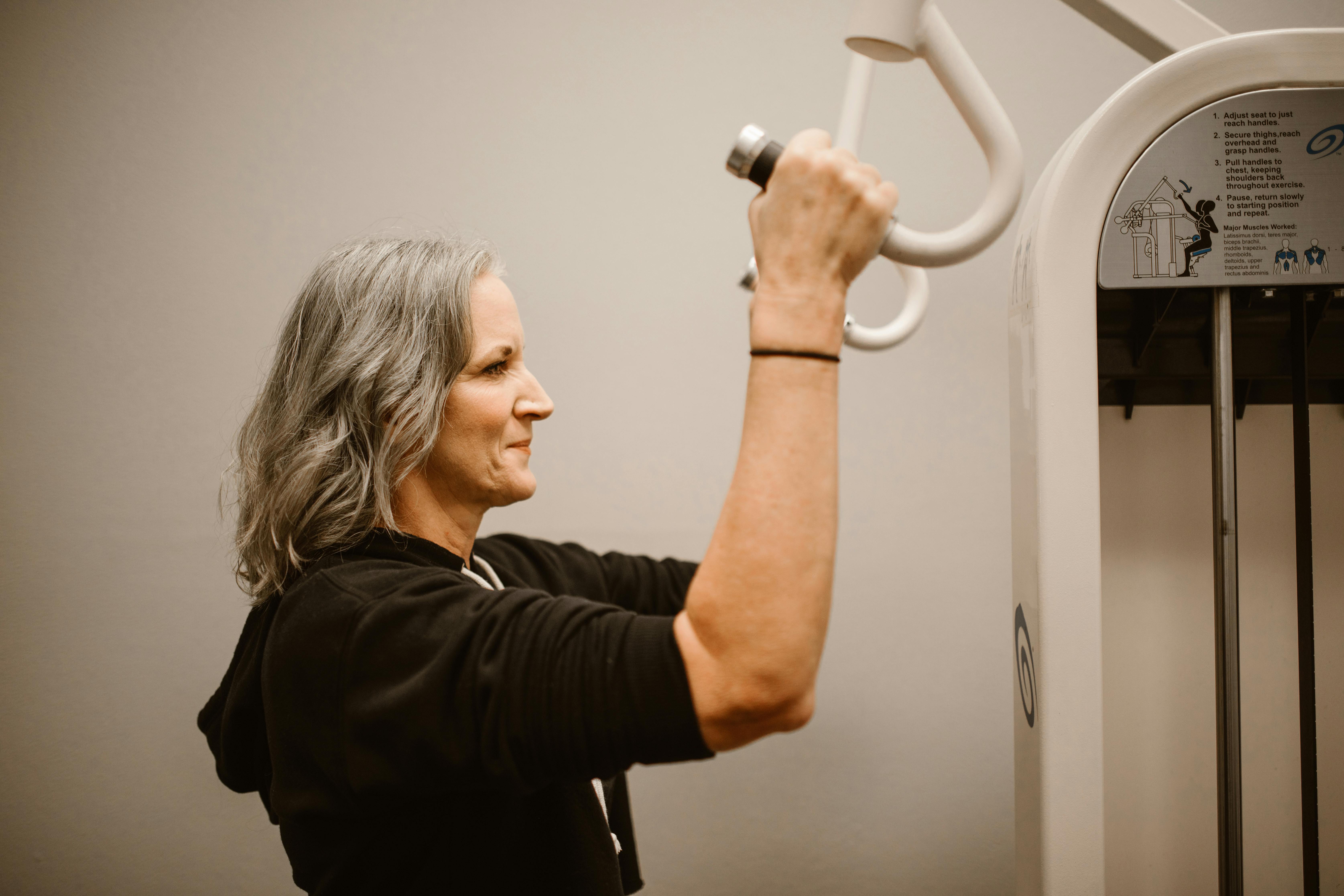 Older woman exercising on gym equipment to strengthen her body and mind