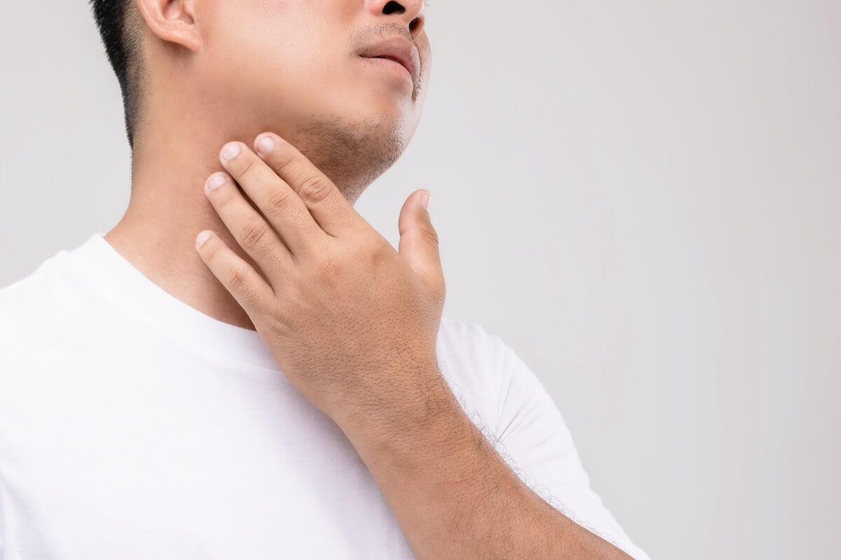 Sudden lump between neck and shoulder: man touching his neck