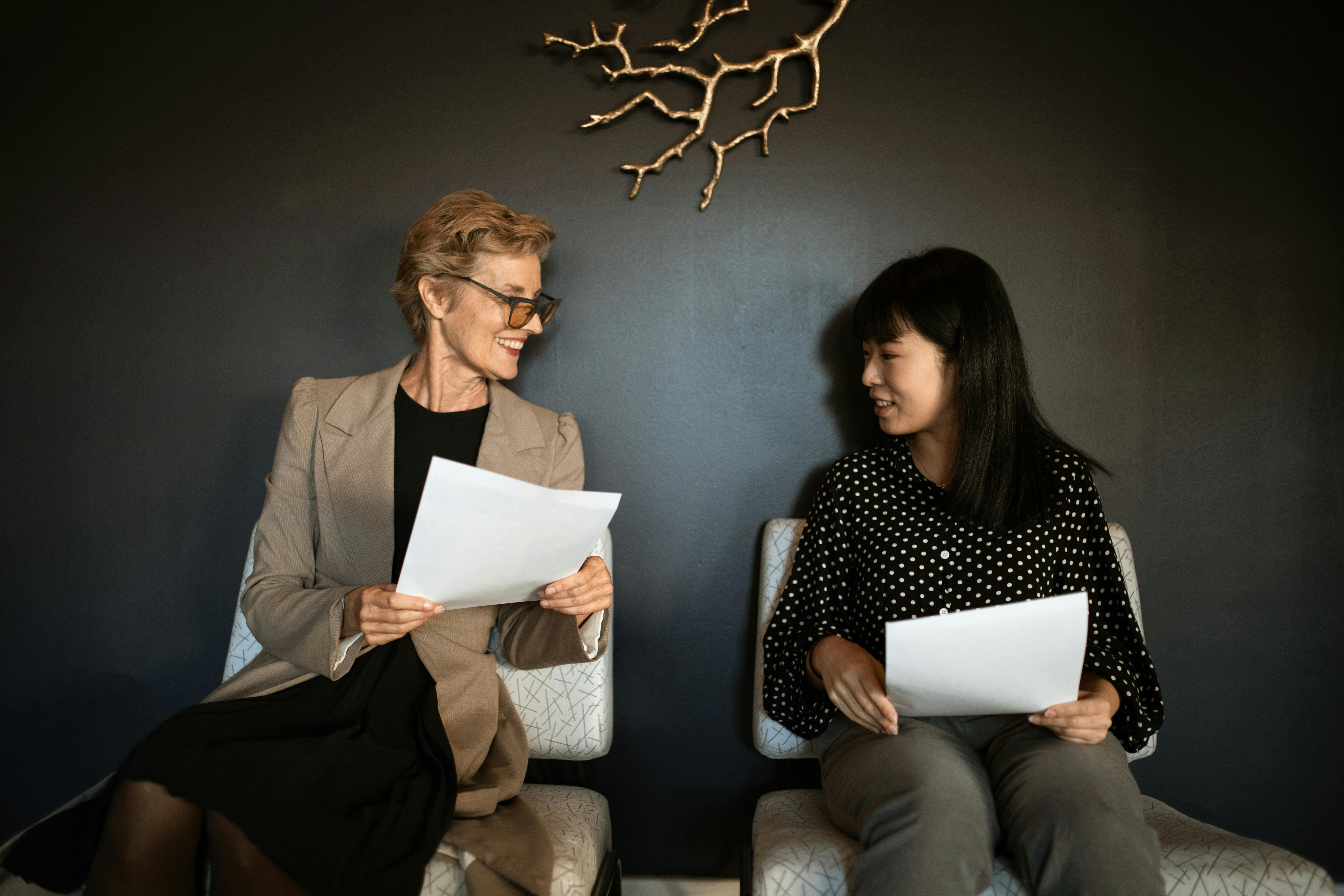 Two patients sitting on a chair speaking to each other