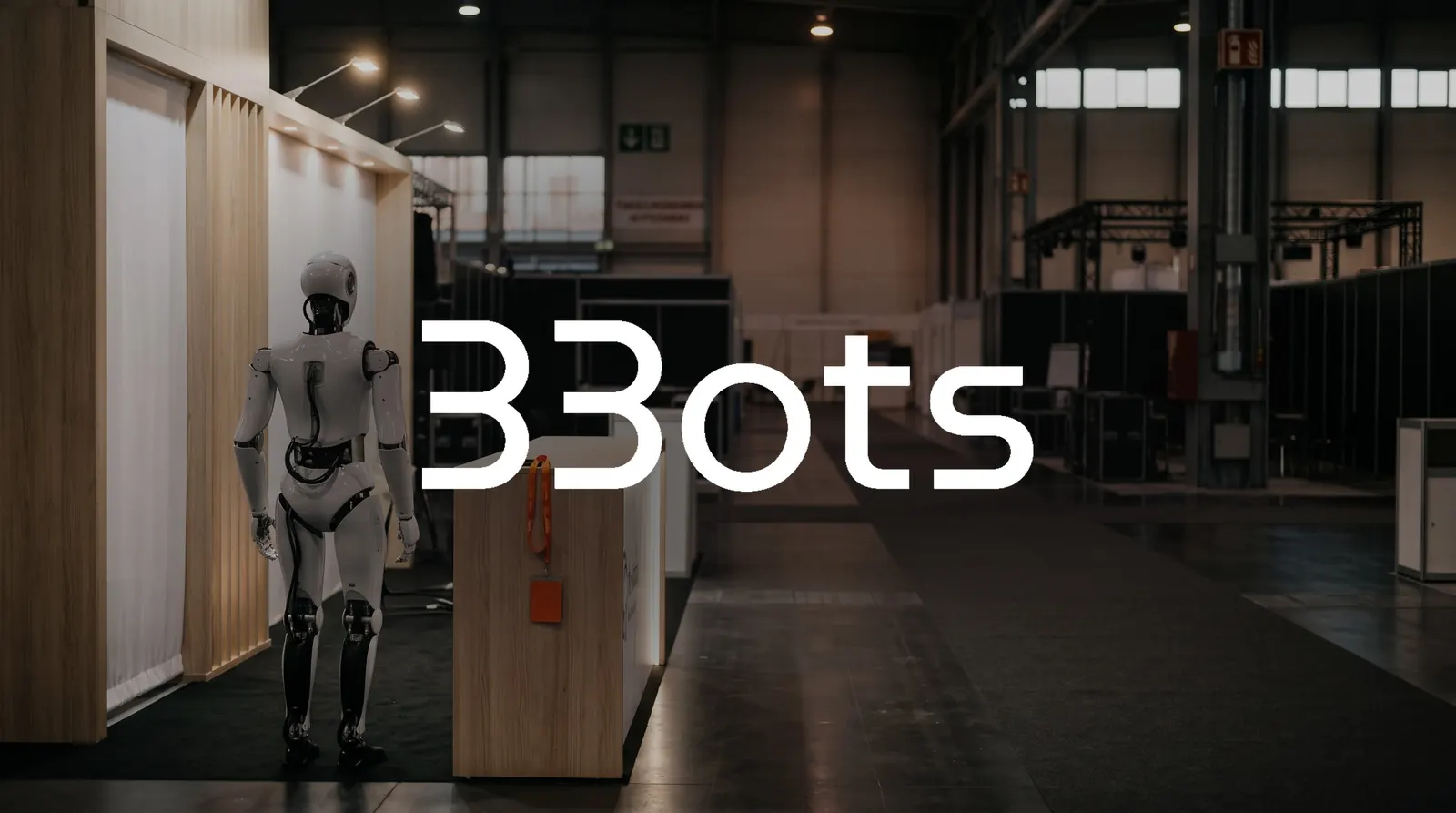 Pusta hala targowa z robotem humanoidalnym przy stoisku z logo 33Bots - leady od firm planujących eventy
