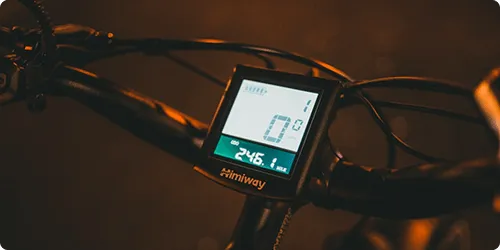 Handlebar-mounted digital display on a bike showing speed and distance.
