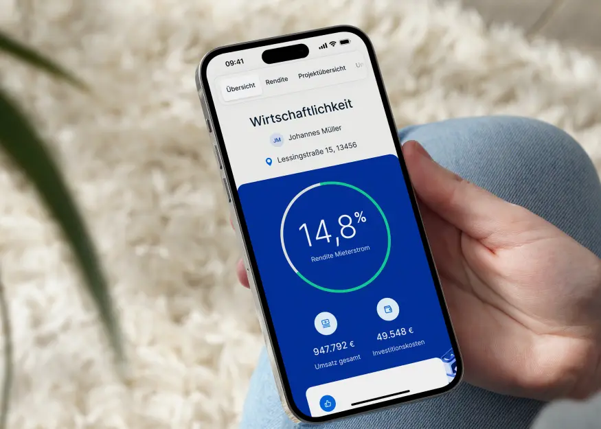 Smartphone zeigt eine Wirtschaftsübersicht mit 14,8 % Rendite für Mieterstrom, Gesamtumsatz 947.792 € und Investitionskosten 49.548 €.