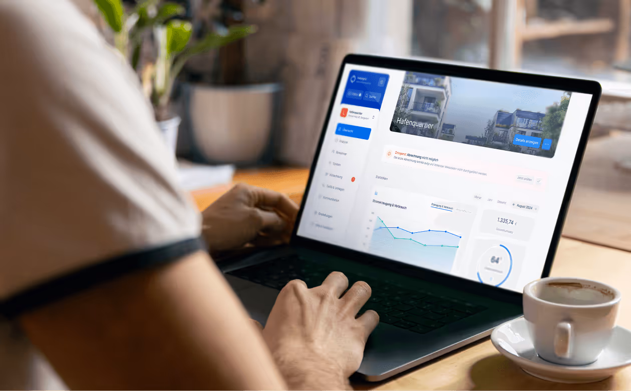 Person bedient auf einem Laptop eine Benutzeroberfläche für Immobilienmanagement mit Diagrammen und Bildern von einem Hafengebiet.