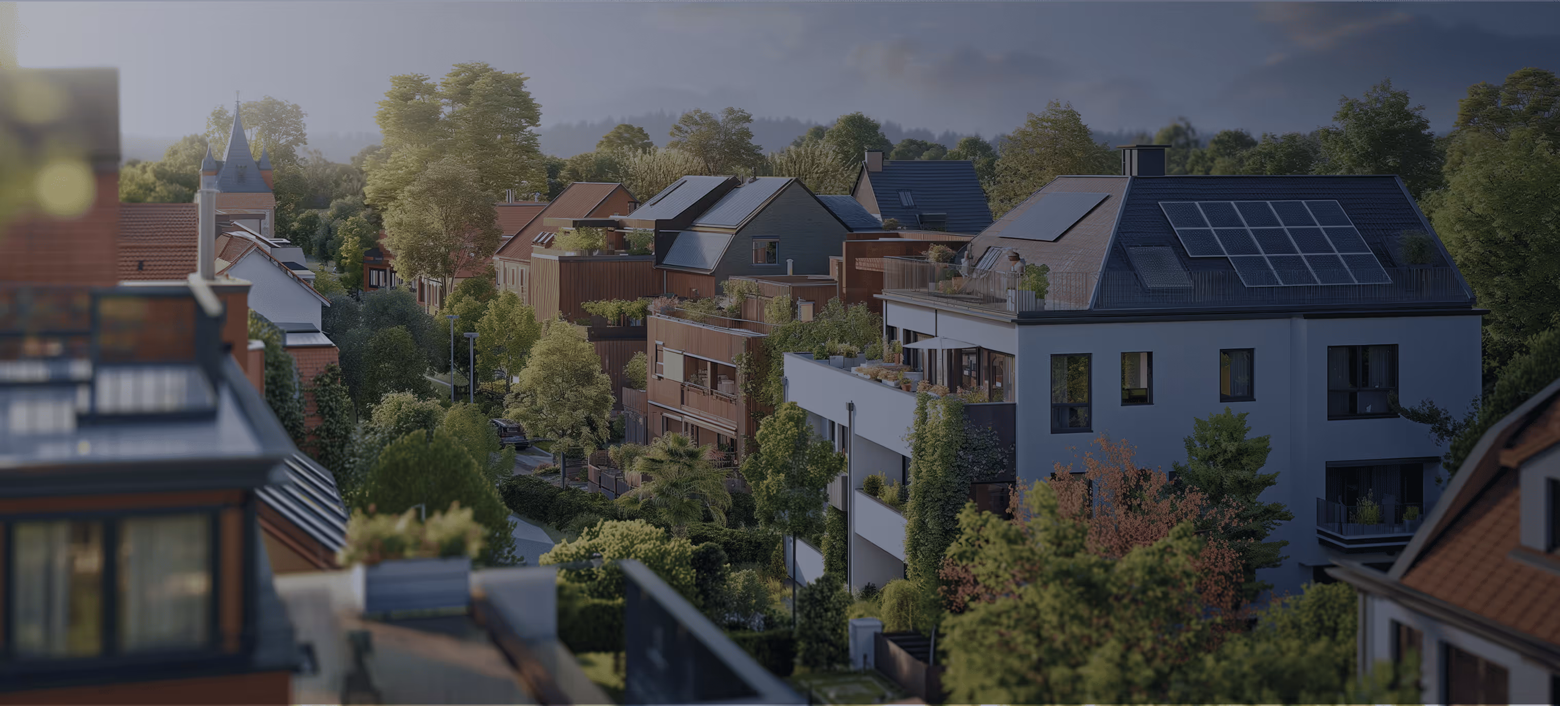 Blick auf ein modernes Wohngebiet mit mehreren Häusern, die mit Solarpaneelen auf den Dächern ausgestattet sind, umgeben von vielen grünen Bäumen.