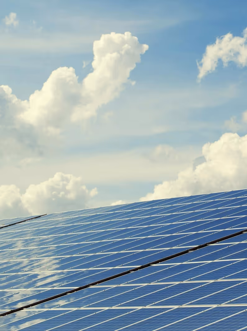 Solarmodule, die das reflektierte Licht unter einem bewölkten Himmel einfangen.