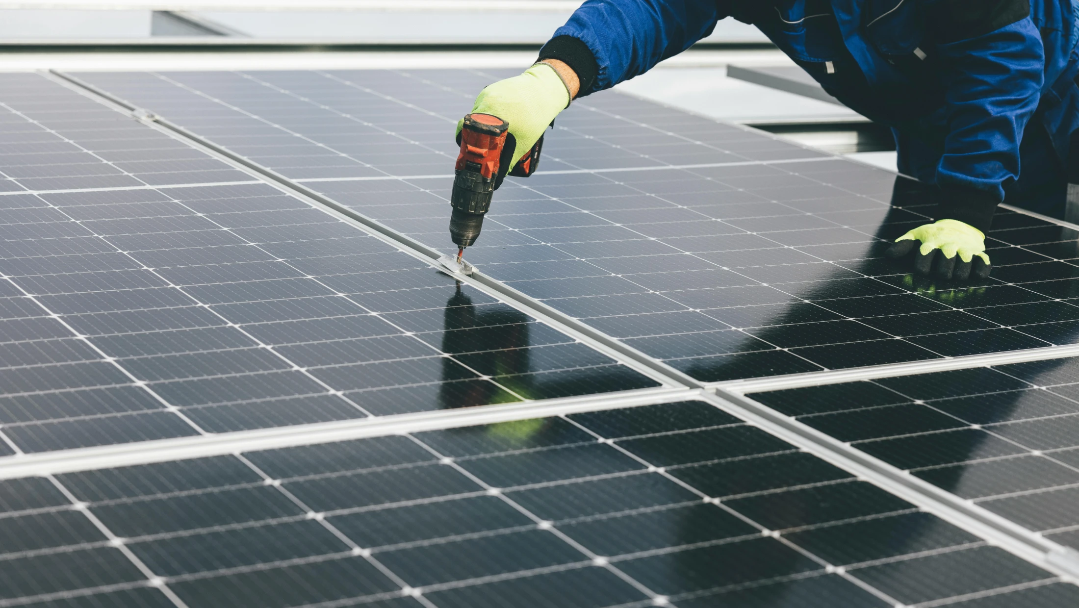Elektiker auf dem Dach eines Mehrfamilienhauses zur Installation der PV-Anlage | Mieterstrom mit metergrid