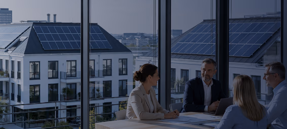 Geschäftsleute aus der Immobilienwirtschaft, Wohnungswirtschaft vor Mehrfamilienhäusern mit Photovoltaik und Mieterstrom