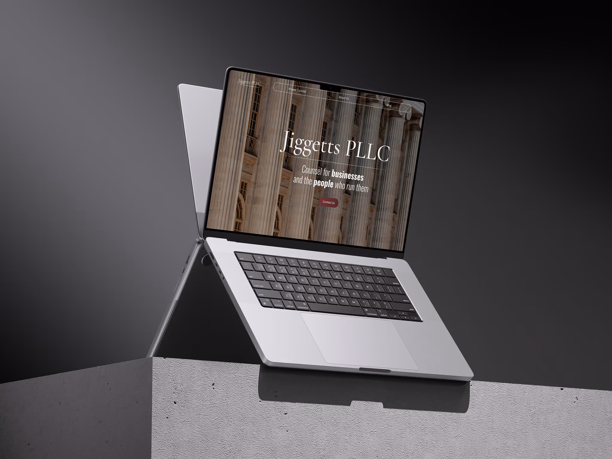 Silver laptop on a concrete ledge displaying Jiggetts PLLC homepage with columns background and business counsel message.