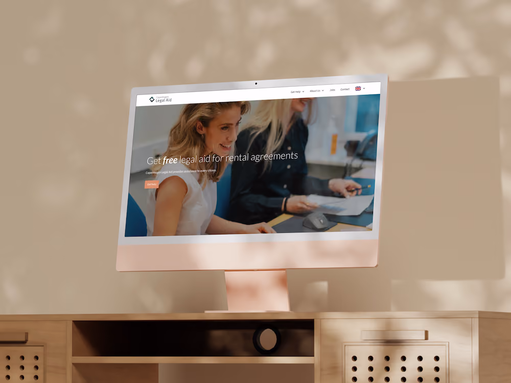 Desktop computer on wooden desk displaying a webpage of Equity in tech group with a photo of a woman working on a laptop by a window and green plant beside the desk.