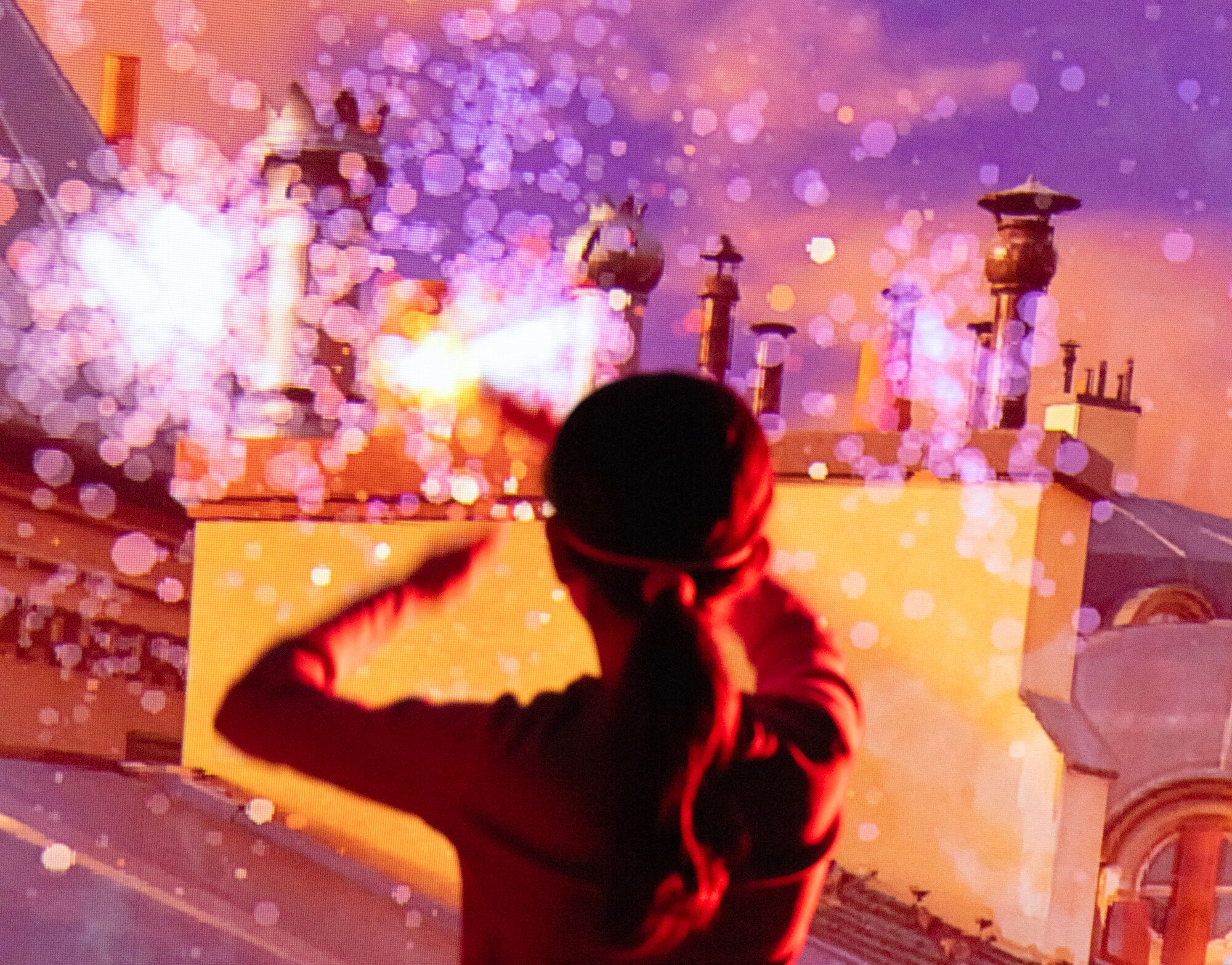 Children and adults playing in a red ball-lit room with a glowing sign reading 'Toucher les cibles avec les balles'.