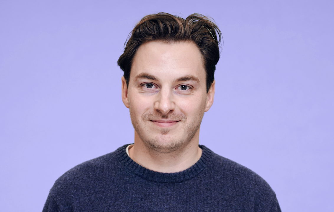 A headshot of jack Wilson, who is white, has short brown hair and brow eyes, and looks in his late twenties.