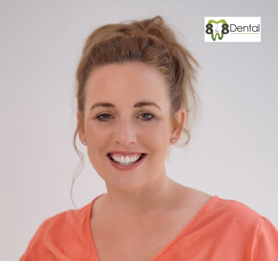 Smiling woman with her hair tied back wearing a coral shirt and earrings, with 8 to 8 Dental logo in the top right corner.
