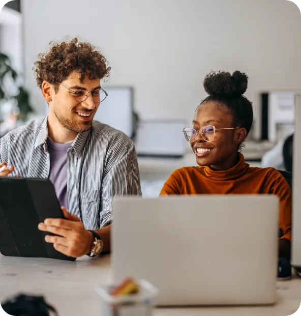 two smiling co-workers looking at data and gaining visibility into the day to day operations of the business powered by ncr voyix