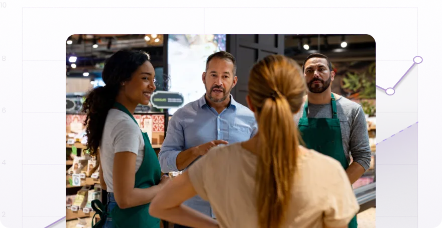 grocery store employees talking to customers in the produce section