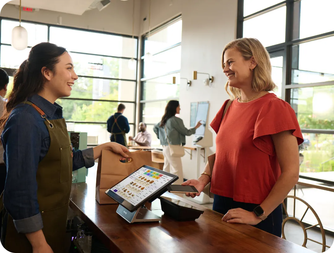 female server interacting with a customer at the front counter of a fast casual style restaurant