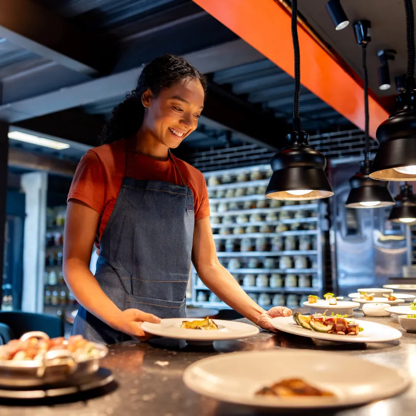 server picking up orders from the kitchen from a serving line