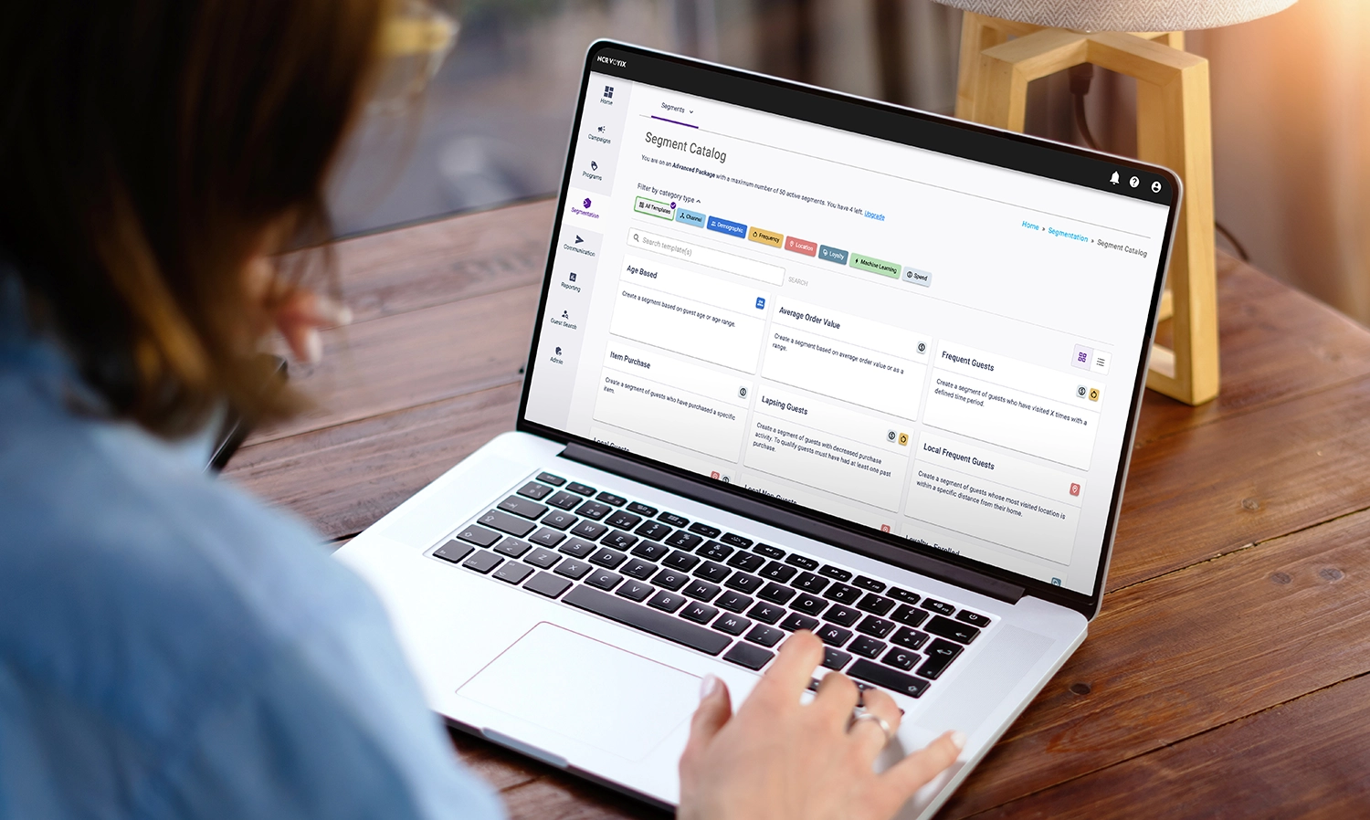 Person using laptop showing a segment catalog interface for marketing segmentation options.