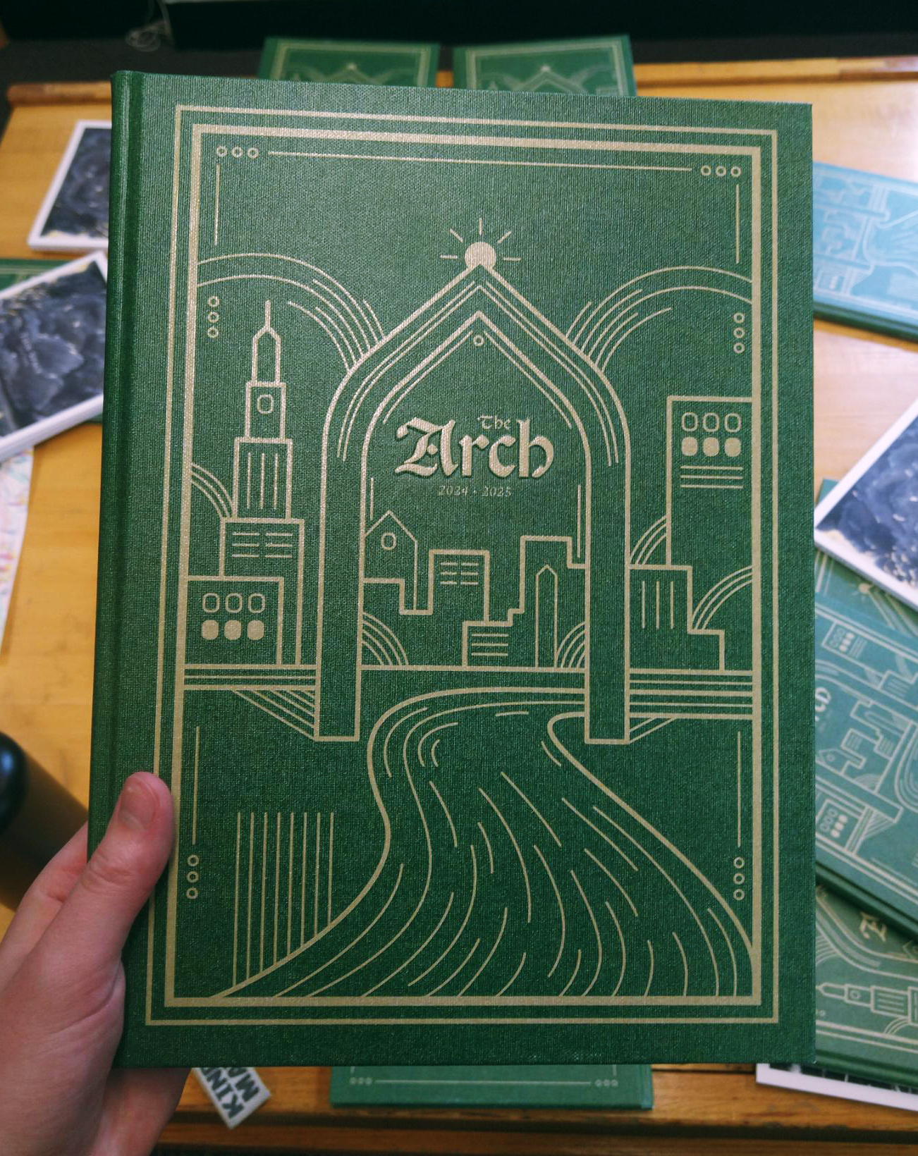 Moody Bible Institute ARCH 2025 yearbook cover with gold Chicago architecture linework on green