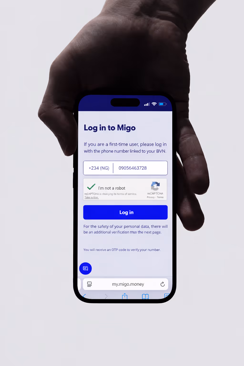 A hand holding a smartphone showing a login screen for Migo, with phone number input, captcha, and a blue Log in button.