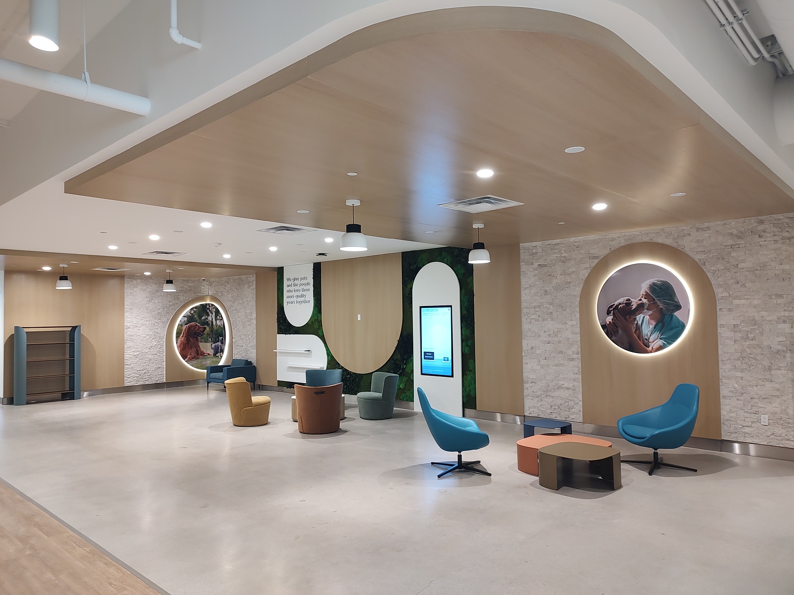 Backlit circular pet photography panels and a digital directory in a veterinary clinic lobby