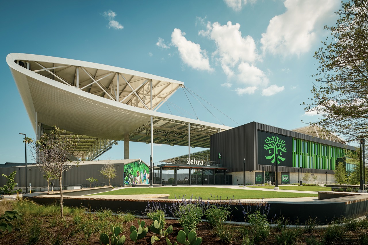 Branded green tree-logo facility exterior beside a stadium with Zebra entrance signage
