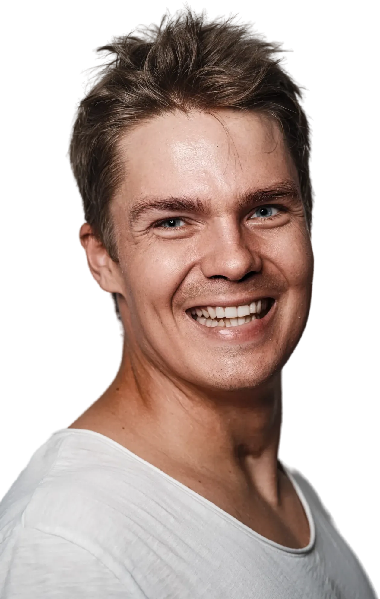 Lähikuva hymyilevästä, vaaleahiuksisesta miehestä valkoisessa paidassa mustaa taustaa vasten, jossa on siniset silmät ja hyvä valaistus.