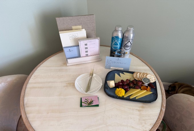 Dining table in a guest room at Four Seasons Resort Palm Beach used as a workspace with a Four Seasons Preferred Partner amenity displayed on the table