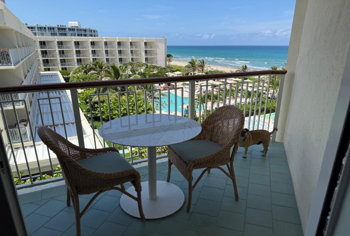 Furnished terrace of my top floor room at Four Seasons Resort Palm Beach with views of the pool and the Atlantic Ocean