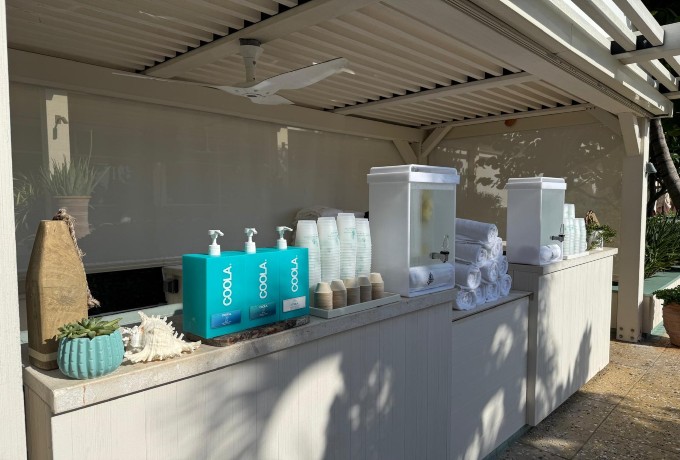 Poolside service bar at Four Seasons Resort Palm Beach stocked with sunscreen, fresh towels and chilled water