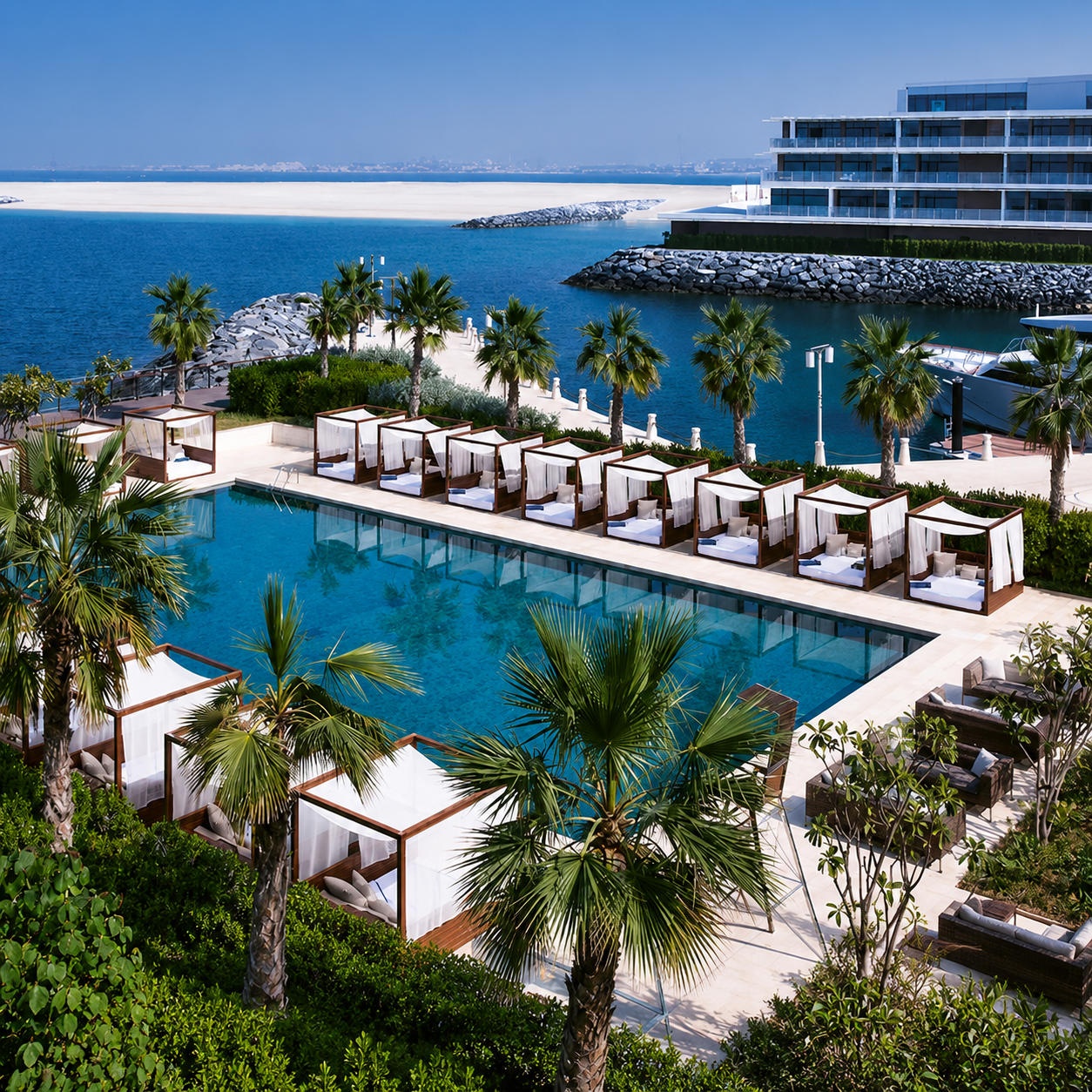 Bvlgari Resort Dubai pool with cabanas, palm trees and marina views.