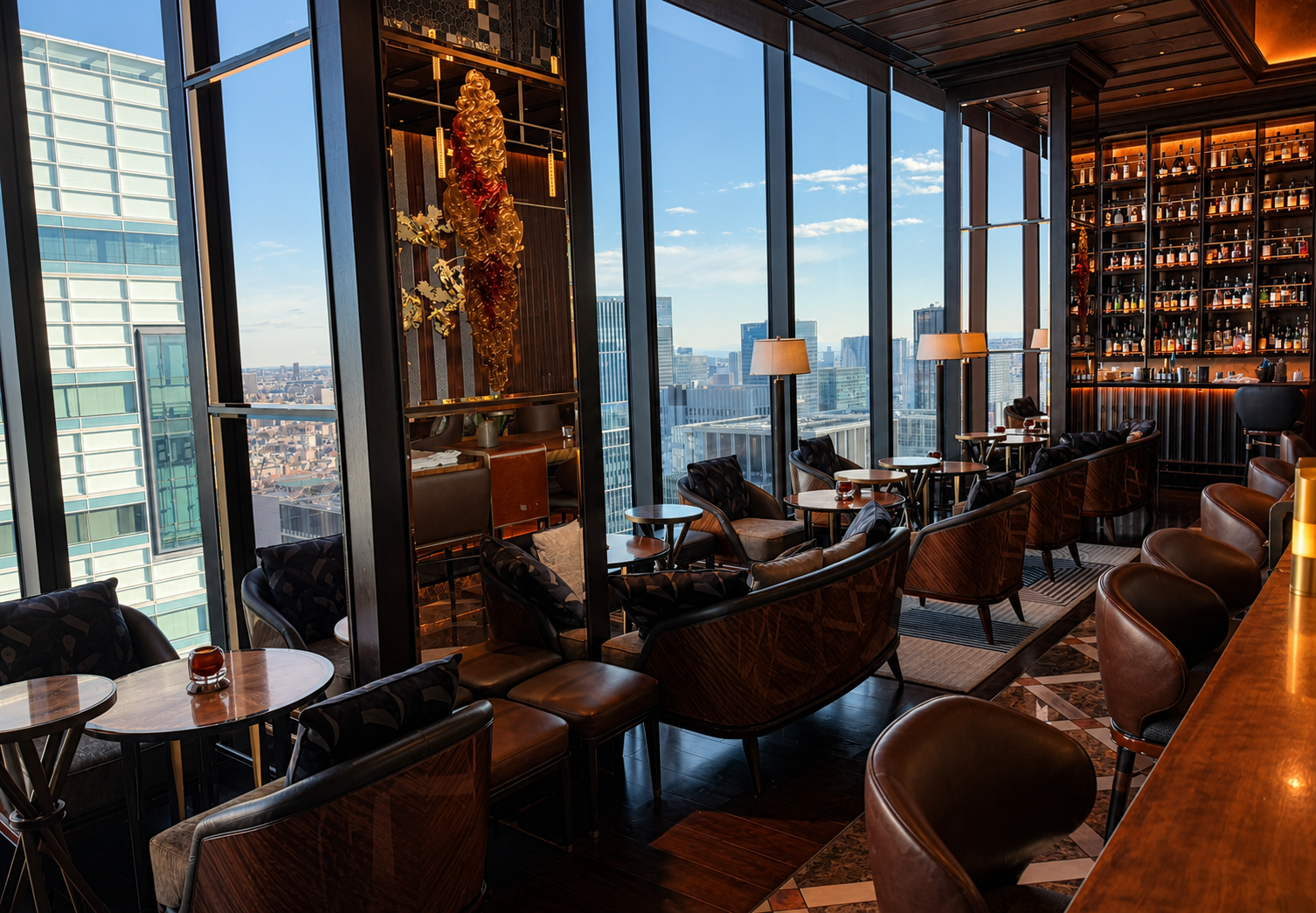 Interior of Virtù bar with leather seating, floor-to-ceiling windows and Tokyo skyline views at Four Seasons Hotel Tokyo at Otemachi.