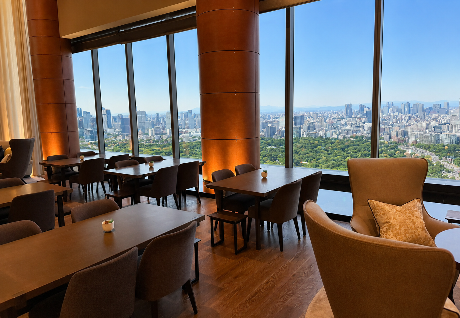 The Lounge at Four Seasons Hotel Tokyo at Otemachi with floor-to-ceiling windows overlooking the Imperial Palace Gardens and Tokyo skyline.