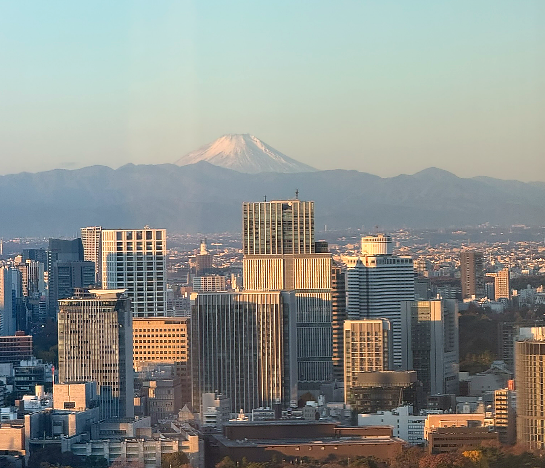 Mount Fuji visible from a guest room at Four Seasons Hotel Tokyo at Otemachi overlooking the Tokyo skyline.