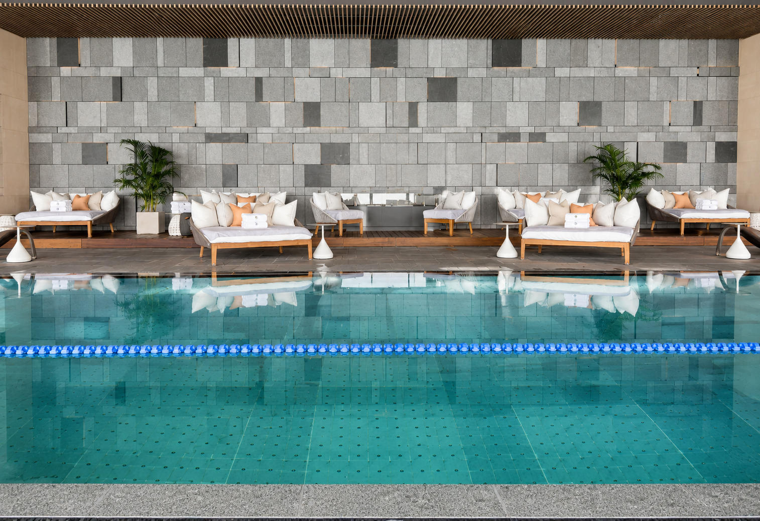 Indoor swimming pool at Four Seasons Hotel Tokyo at Otemachi with daybeds, natural stone finishes and a dedicated lap lane.