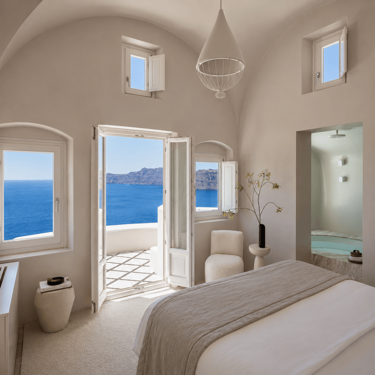 Elegant Small Luxury Hotels of the World suite with vaulted ceilings and sea views, representing the boutique luxury and character of SLH properties.