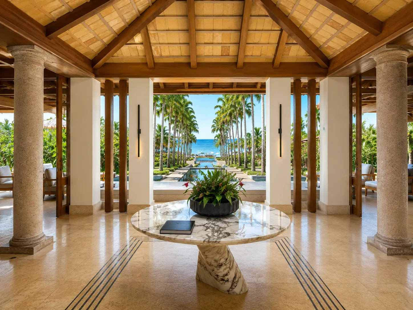 The open-air lobby at The St. Regis Punta Mita overlooking palm-lined gardens and the Pacific Ocean.