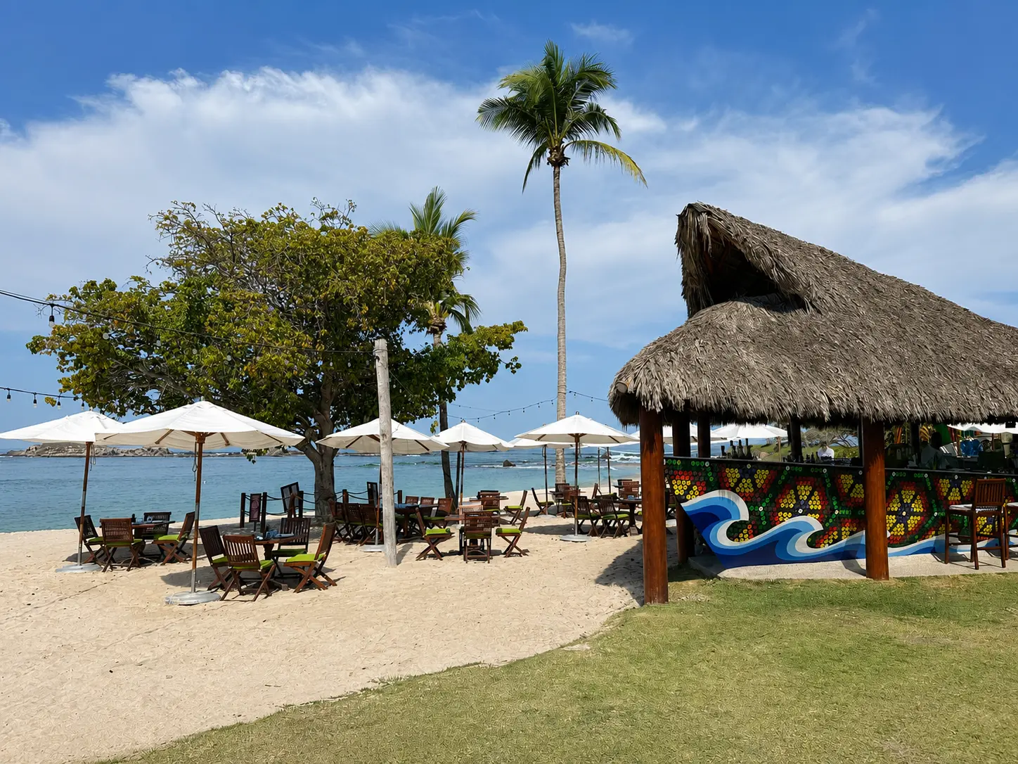 Mita Mary beachfront restaurant and bar at The St. Regis Punta Mita, with tables on the sand and ocean views.
