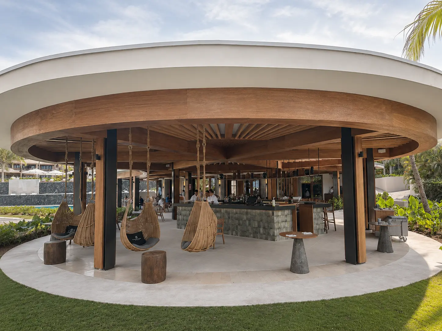 Sea Breeze Bar at The St. Regis Punta Mita with a circular open-air design, hanging wicker chairs, central bar and tropical gardens.