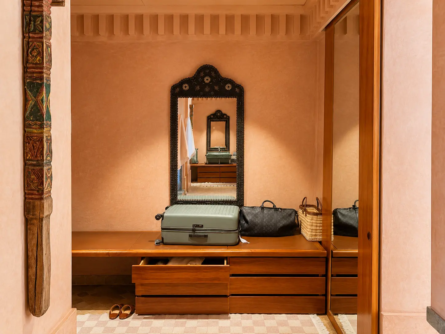 Spacious dressing area inside a Deluxe Pavilion at Amanjena Marrakech with wardrobes, drawers, bench seating, and luggage storage.