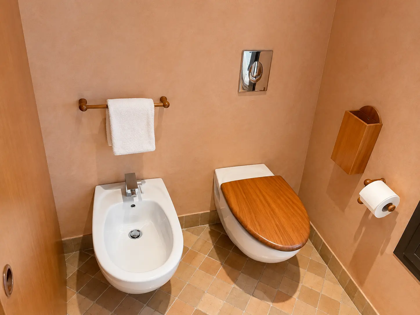 Separate toilet and bidet inside a Deluxe Pavilion at Amanjena Marrakech with warm Moroccan plaster walls and timber finishes.