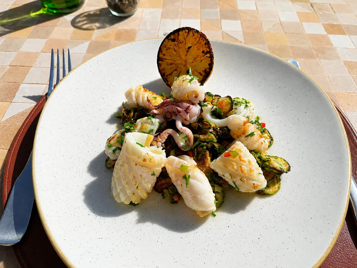 Grilled squid and baby octopus served with charred zucchini and grilled lemon at the Olive Grove restaurant at Amanjena in Marrakech.