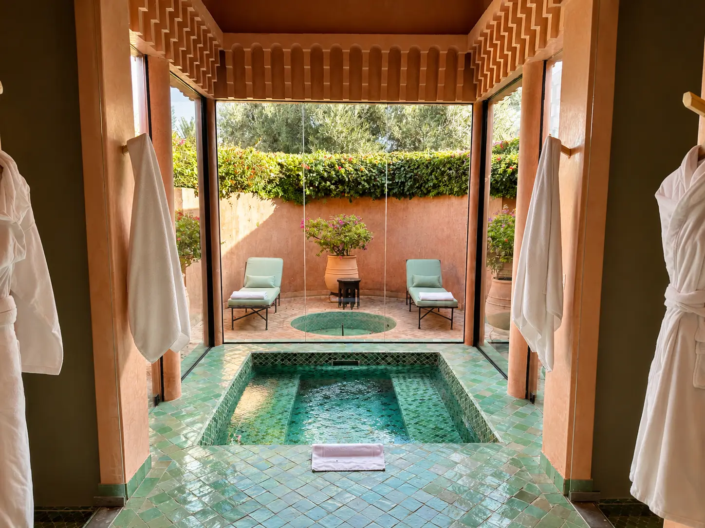 Private hydrotherapy pool at Amanjena Spa in Marrakech with green zellige tiles, floor-to-ceiling glass, outdoor plunge pool, and relaxation loungers.