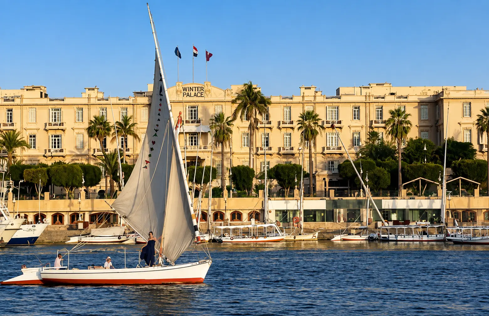 Mandarin Oriental Winter Palace Luxor overlooking the Nile with a traditional felucca sailing past.