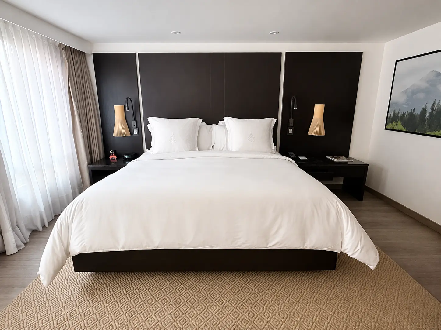 Guest room at Four Seasons Hotel Bogotá with a king bed, dark wood headboard, neutral interiors and large windows.