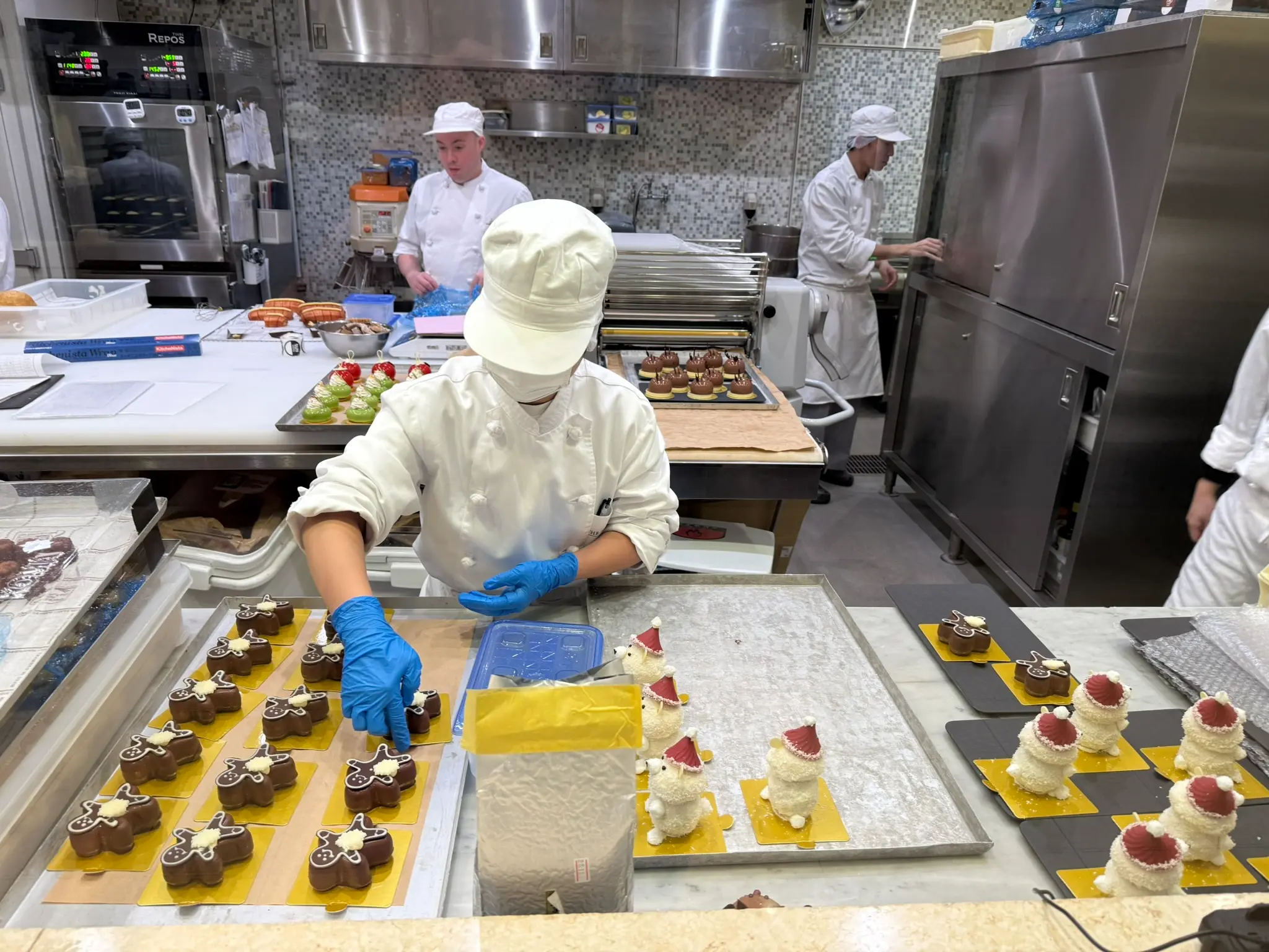 Pastry chefs preparing cakes and Peninsula PenClub welcome amenities in the bakery at The Peninsula Tokyo.