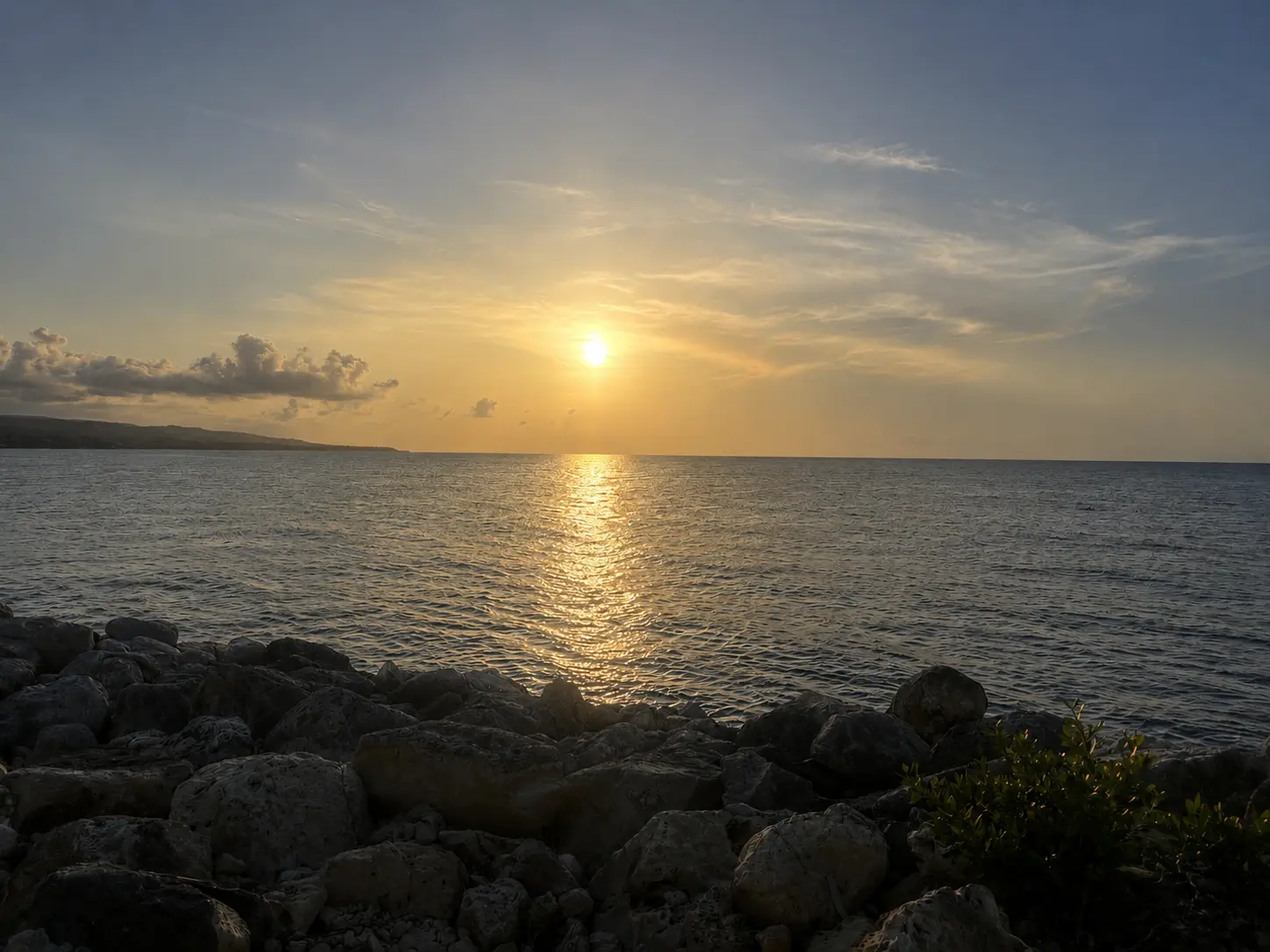 Sunset over the Caribbean Sea at GoldenEye Jamaica, viewed from the rocky shoreline in Oracabessa.