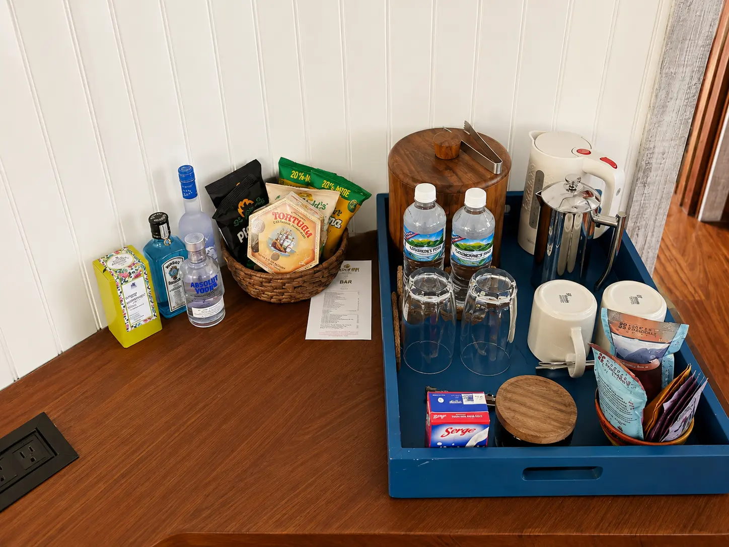 Minibar and coffee station inside a One Bedroom Beach Hut at GoldenEye Jamaica with bottled water, spirits, snacks and coffee.