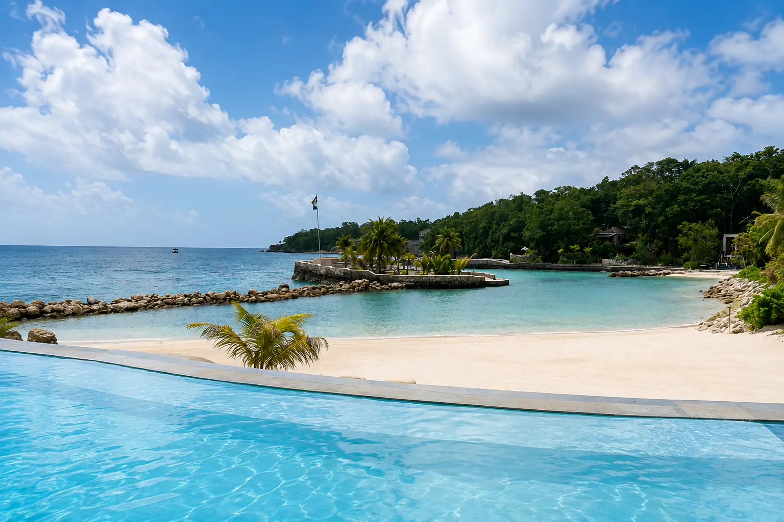 Infinity pool and white sand beach overlooking the Caribbean Sea at GoldenEye Jamaica in Oracabessa.