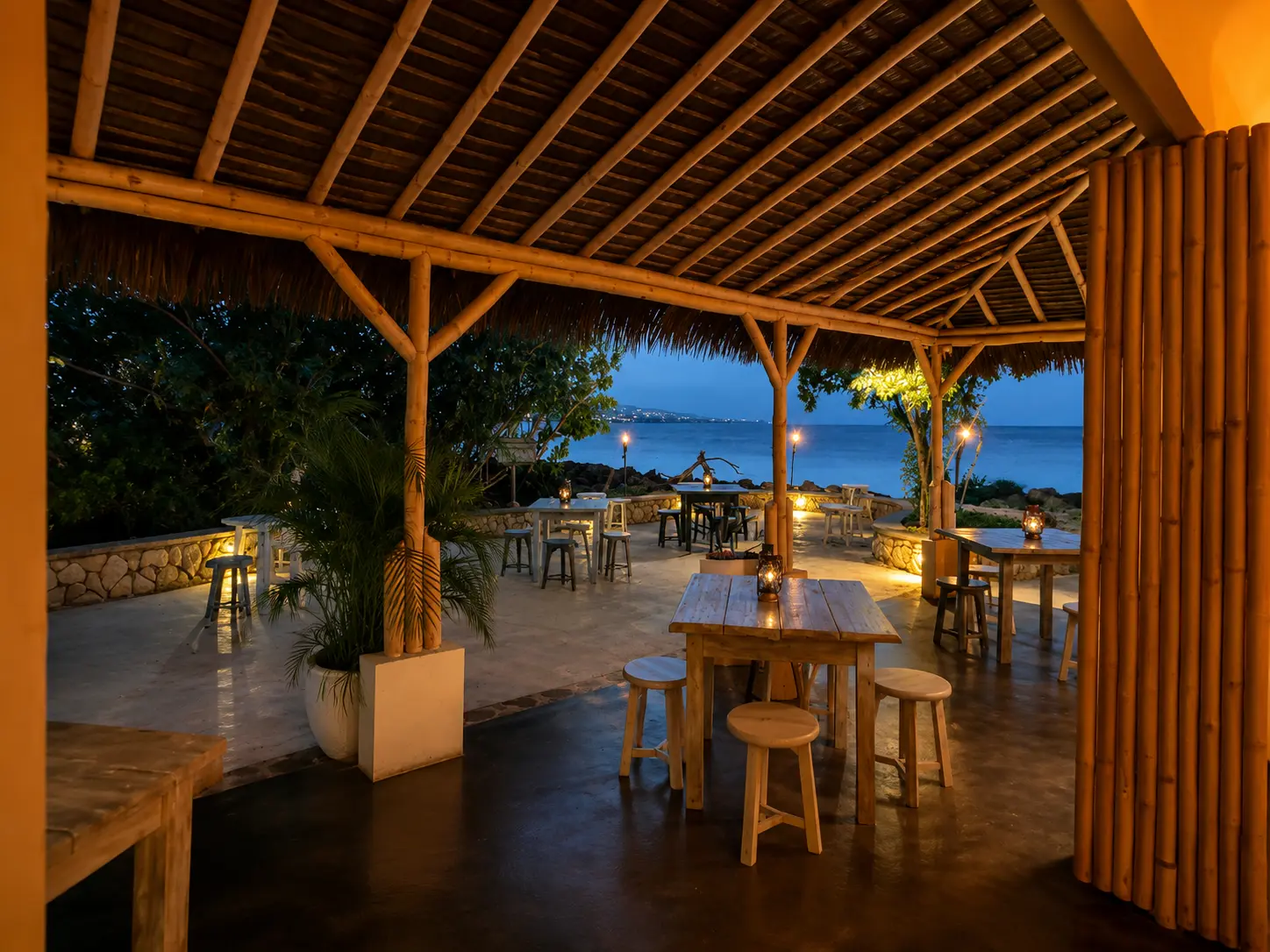 Open-air terrace at Shabeen, GoldenEye Jamaica, overlooking the Caribbean Sea at dusk.
