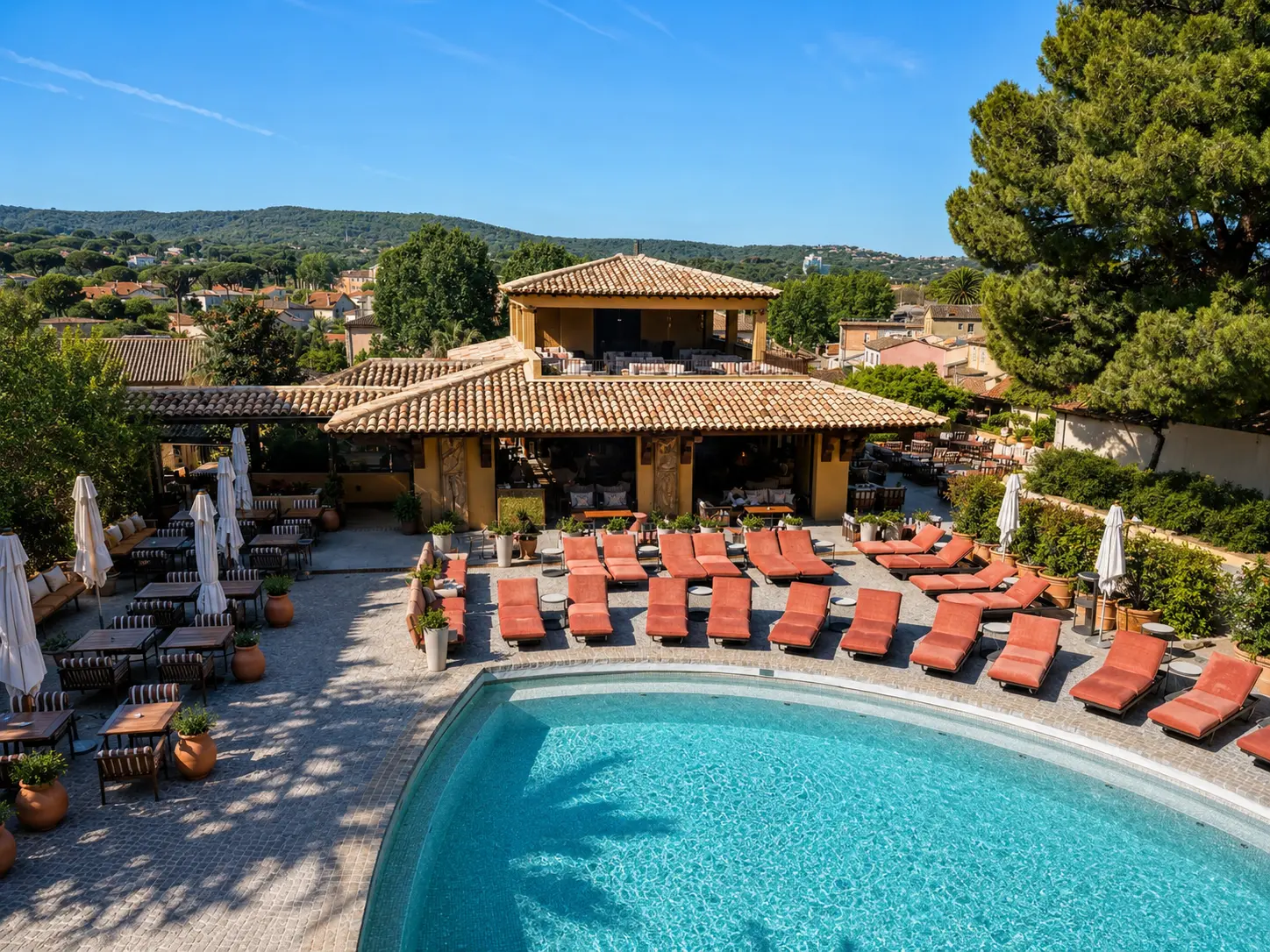 Byblos Saint-Tropez pool surrounded by colorful Provençal-style buildings and palm trees
